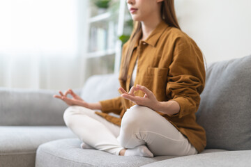 Young woman sitting on the floor and doing meditation practice mindfulness at home