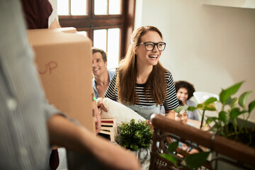 Diverse group of young people moving in their new shared apartment and carrying boxes