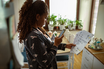 Young woman doing home financials in the kitchen