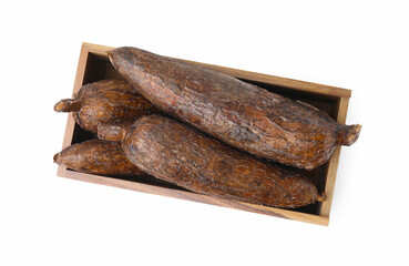 Whole cassava roots in wooden crate isolated on white, top view