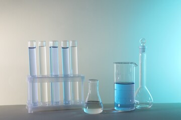 Laboratory analysis. Different glassware on table against color background