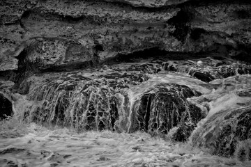 Schizzi di acqua che si infrange contro delle rocce