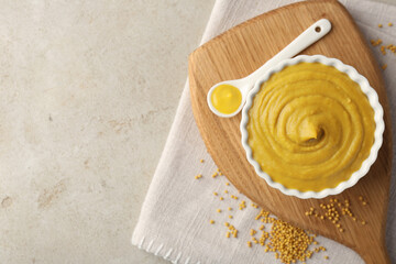 Fototapeta na wymiar Tasty mustard sauce and dry seeds on light textured table, flat lay. Space for text