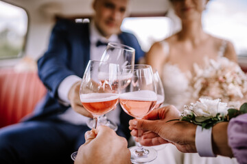 Valmiera, Latvia - July 7, 2023 - Four people are toasting with glasses of rosé wine in a celebratory manner, likely at a wedding