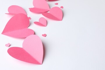 Pink paper hearts on white background. Space for text