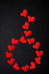background of red decorative hearts on black, vertical top view