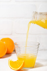 freshly squeezed orange juice is poured into a glass