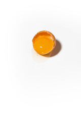 half shell with broken chicken egg on white background, vertical top view