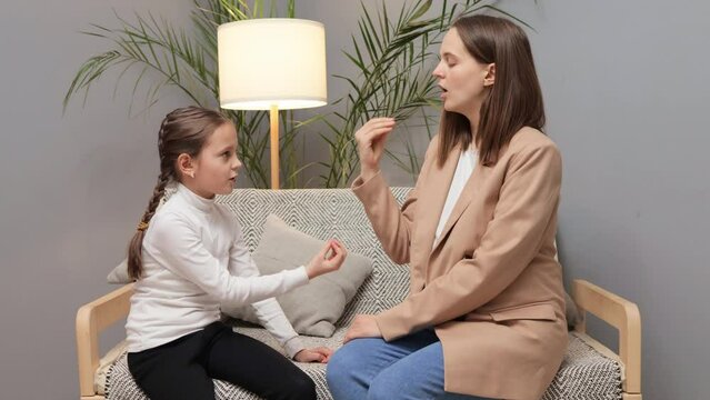 Language development assistance. Private pedagogue support. Learning disorder therapy. Charming stuttering girl and speech therapist doing exercises during private lesson at home