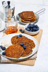 homemade pancakes with fresh blueberries and yogurt on white background