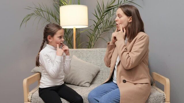 Therapist working with kids. Voice development practice. Lesson with speech specialist. Pediatric language therapy. Little brown haired girl at speech therapist office working with articulation
