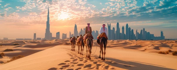 Zelfklevend Fotobehang The image depicts an Arab man leading camels across a desert landscape, with the futuristic skyline of Dubai visible in the background, blending traditional desert life with modern urban development. © vadymstock