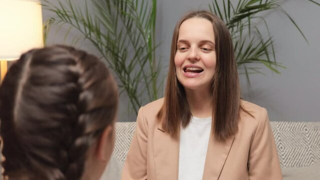 Practice for speech improvement. Educational support for articulation. Pediatric therapy and learning. Speech therapist practicing pronunciation exercises with little girl child while sitting on sofa
