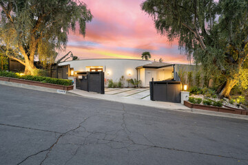 Beautiful sunset casts pink and orange hues over a home