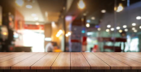 Empty wooden table top with lights bokeh on blur restaurant background.