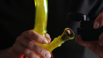 Burning And Smoking Hemp Leaves From A Bong, Flame Close-Up, With Female Hands