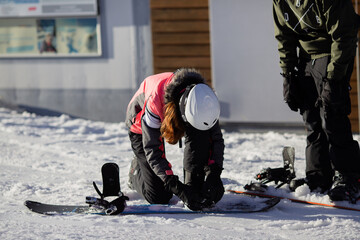 Snowbordfahrerin macht ihre Schuhe zu