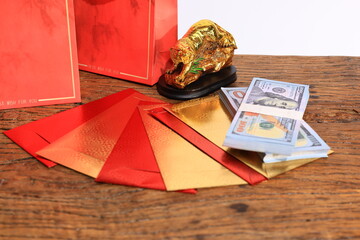 Present package of money US dollars, red bag, red and gold envelope  on a wooden background in Chinese New Year Festival 