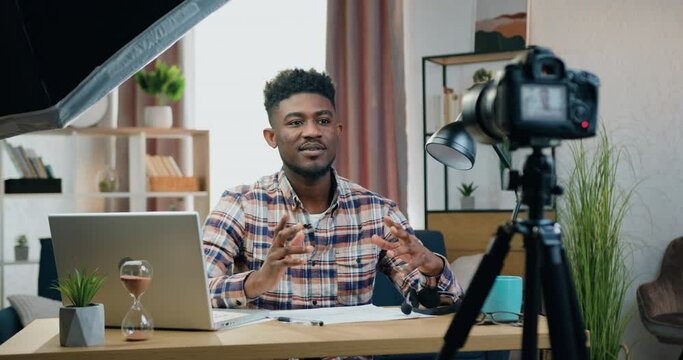 African american influencer man sitting in front of camera at home and recording new videoblog for his followers blogging concept