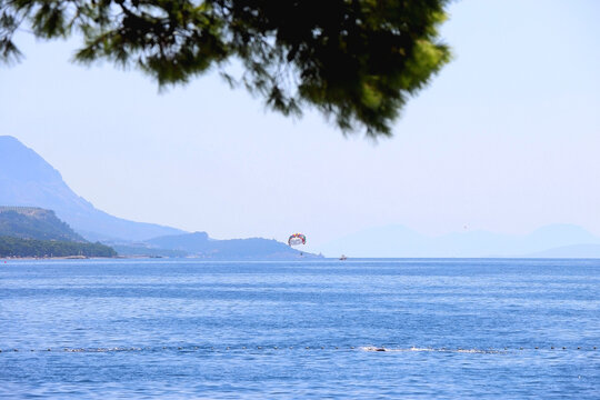 Beautiful seaside landscape and parasailing parachute in Brela, Croatia.