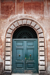 Fototapeta na wymiar Patinated door and weathered wall in Roma city