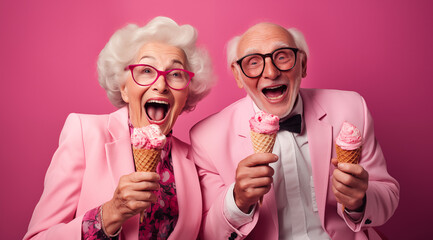 Un couple senior, heureux, amoureux, mangeant une glace, arrière-plan rose.