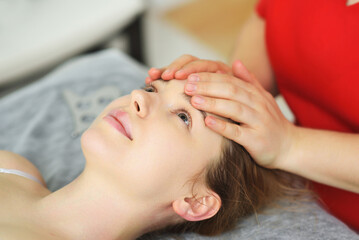 Fototapeta na wymiar specialist gives a relaxing facial massage to a young woman patient. Facial care