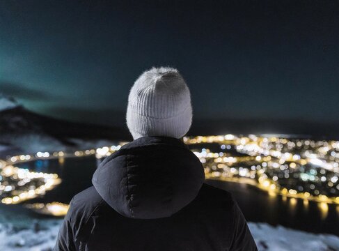 A Person Overlooking A City In The Arctic Circle At Night