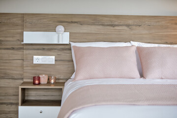 Description: Chic bedroom with wooden headboard and pink bedding.