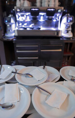 Coffee cup plates with sugar sachets over bar counter