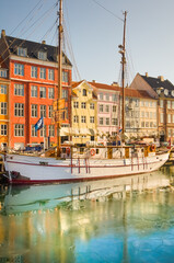 Copenhagen, Denmark - 2 4 2013: Colorful houses and white idyllic sailboat in Nyhavn, Copenhagen...