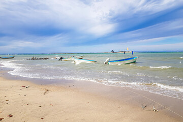 Mexican coastal maritime beach landscape, motor boat anchored above water on shore, horizon against...
