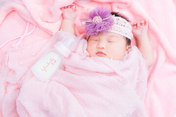 Girl sleeping with pink blanket,A newborn baby girl is sleeping on a pink blanket and is wearing a hat. Use it for a childhood, parenting or innocence theme. Add your text message to the side.