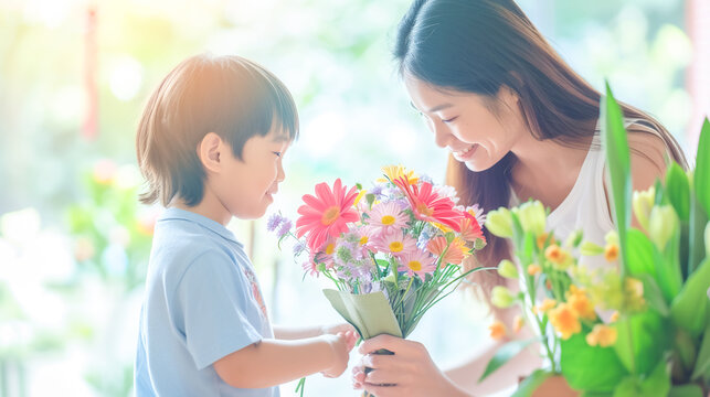 Joyful Asian woman receives bouquet of flowers from little boy. The son congratulates his mother , March 8, Mother's Day