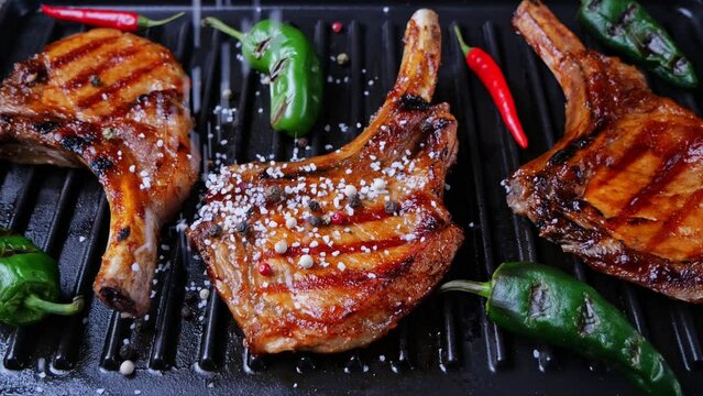 Lamb pork chops on grill sprinkle with salt and spices. Loin on ribs. Slow motion
