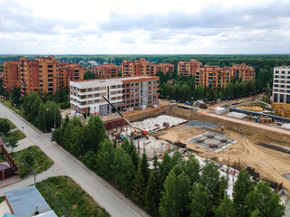 the construction site of an apartment building in the summer from a height