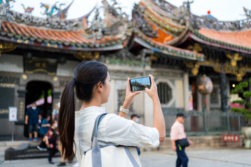 Tourist woman use cellphone to take photo in Chinese temple