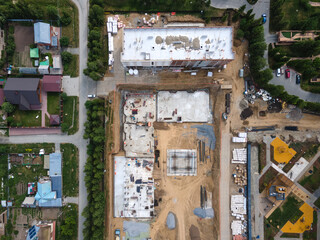 the construction site of an apartment building in the summer from a height