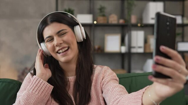One woman with headphones at home listen music online happy smile sing