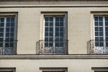Fototapeta na wymiar Facade with windows in an old tenement house in France, French architecture.