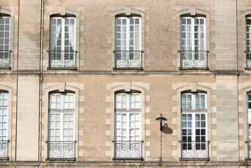 Fototapeta na wymiar Facade with windows in an old tenement house in France, French architecture.