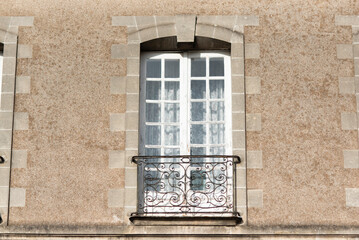 Facade with windows in an old tenement house in France, French architecture.