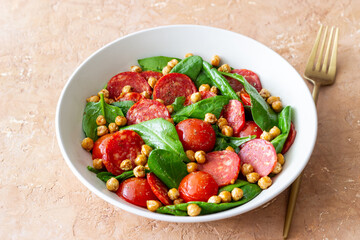 Salad with spinach, sausage, tomatoes and chickpeas. Healthy eating. Diet.