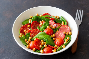 Salad with spinach, sausage, tomatoes and chickpeas. Healthy eating. Diet.