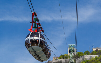 Gondola bubbles against the blue sky. Cable car taking tourists to Fort de La Bastille in Grenoble,...