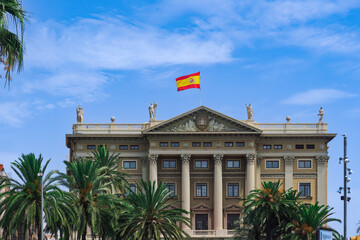 Military Government of Barcelona neoclassical building - Gobierno Militar de Barcelona -with Spanish flag waving on top in Catalonia, Spain.