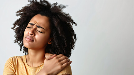 woman in pain touching her shoulder