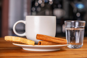 a cup of espresso, a small glass of sparkling water and cookies