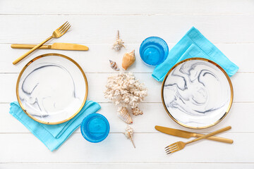 Beautiful table setting with marine decor on white wooden background