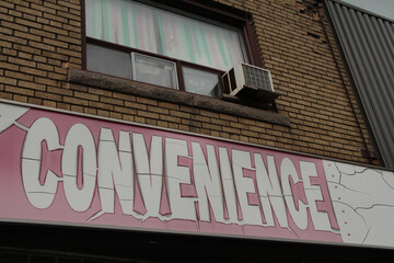 sign that says convenience in old worn faded cracked white capital letters on white background...